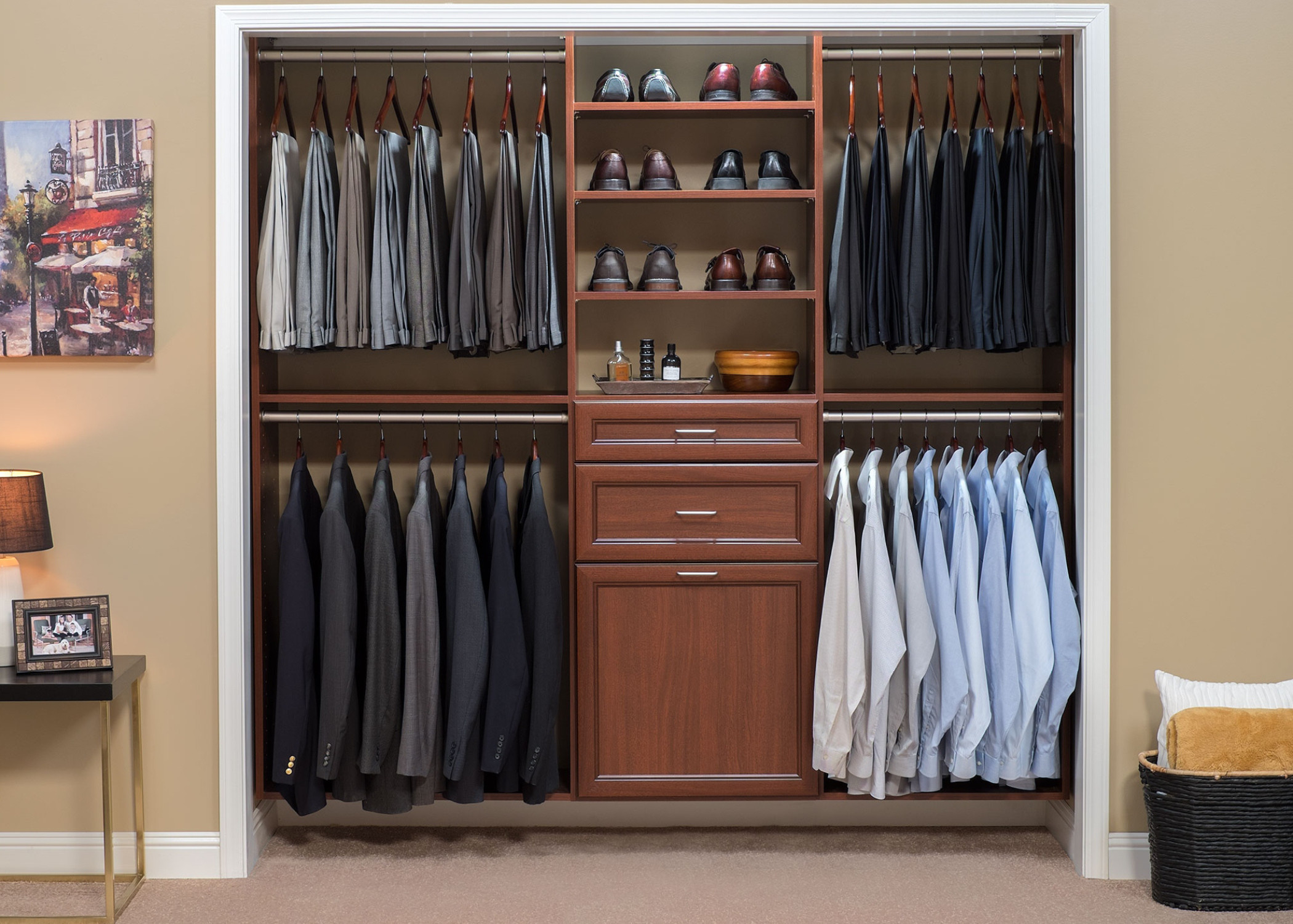 Reach-in closet with mahogany cabinetry featuring organized dress shirts, suits, and dedicated shoe shelving with central drawer storage.