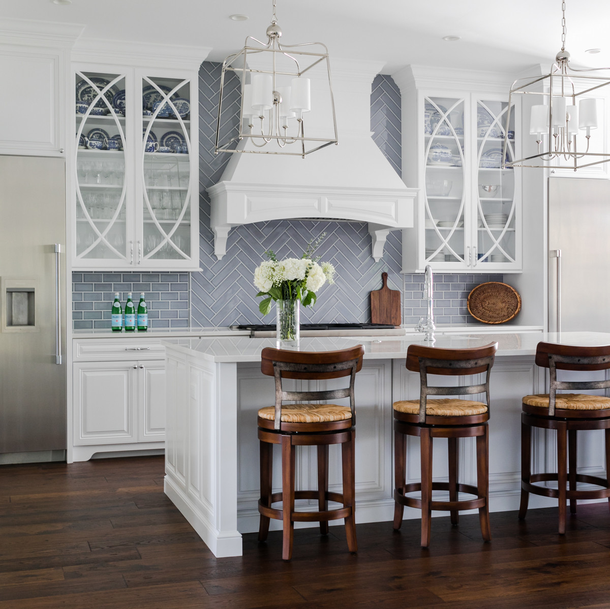 Red Smeg refrigerator anchors a kitchen with white shaker cabinets, subway tile, butcher block counters, and dark wood floors.