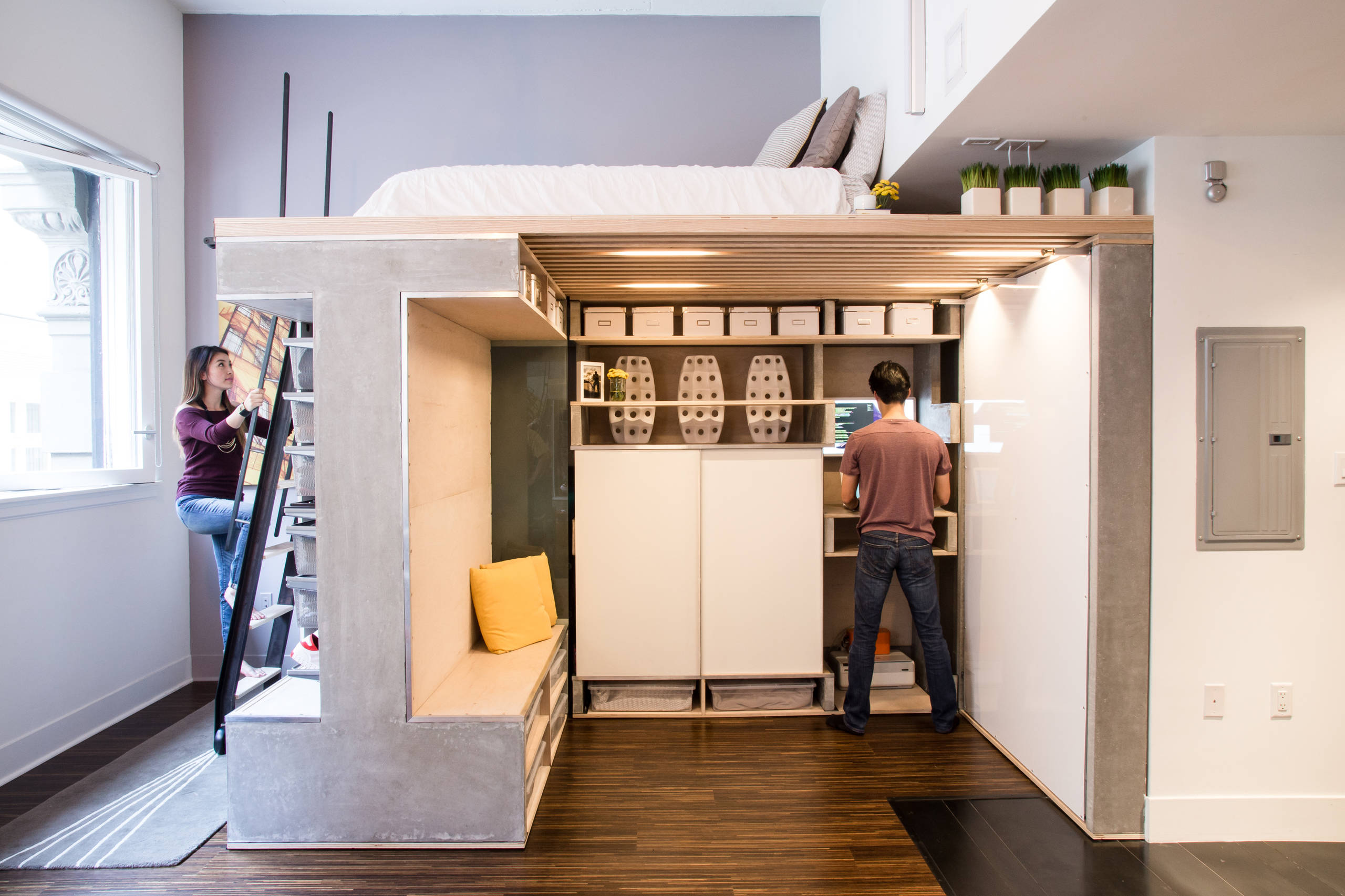 Modern loft with integrated concrete and wood structure, sleeping platform, built-in desk, and storage.
